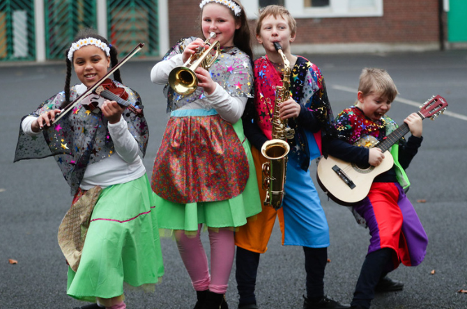 Four children playing instruments funded by the Music Capital Scheme