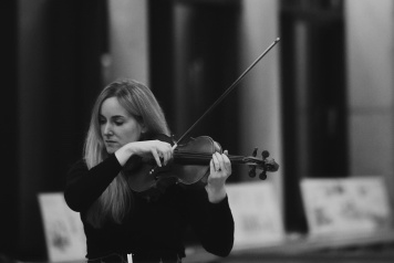 Black and white photo of fair haired woman playing the violin