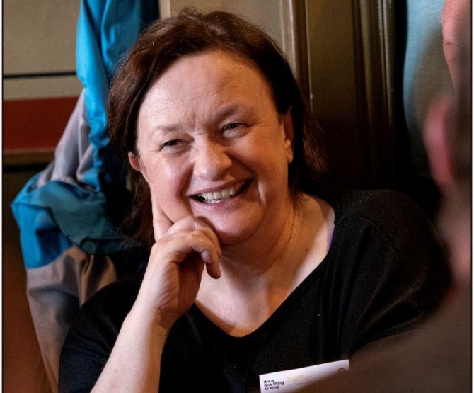 Grace Toland a woman with dark hair sits in a chair smiling